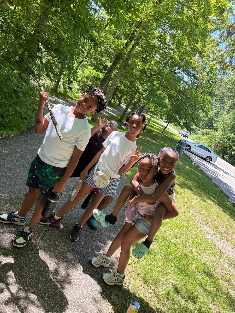 School-age children smiling together on a nature trail outing